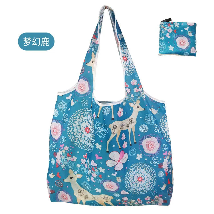 A reusable eco tote shopping bag featuring a blue background with white and pink floral patterns and a silhouette of a deer.