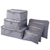 A set of three grey laundry pouches or packing cubes for travel organization.