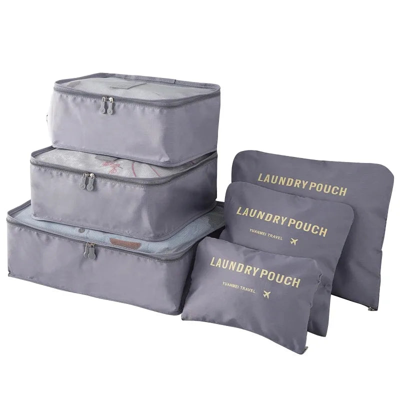 A set of three grey laundry pouches or packing cubes for travel organization.