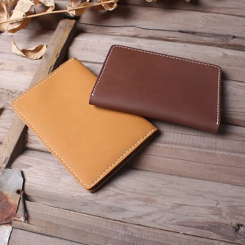 A brown leather passport and ticket holder resting on weathered wooden planks.