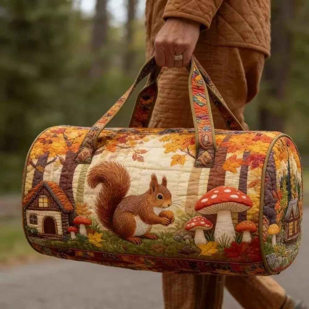 A quilted travel duffel bag with a woodland theme featuring trees, mushrooms, and autumn leaves.