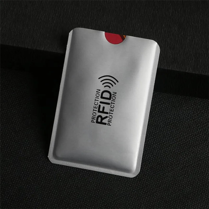 A silver anti-RFID blocking card holder is shown against a dark background.