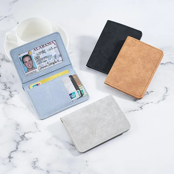A collection of various card wallets and card holders in shades of blue, black, tan, and gray on a white marble surface.