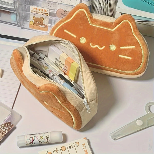 A soft orange cat-shaped plush pencil pouch with a zipper, resting on a white surface.