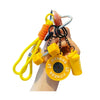 A hand holds a yellow fitness keychain featuring a dumbbell and kettlebell charm.