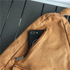 A tan canvas crossbody bag with a zippered pocket and a black smartphone visible inside.
