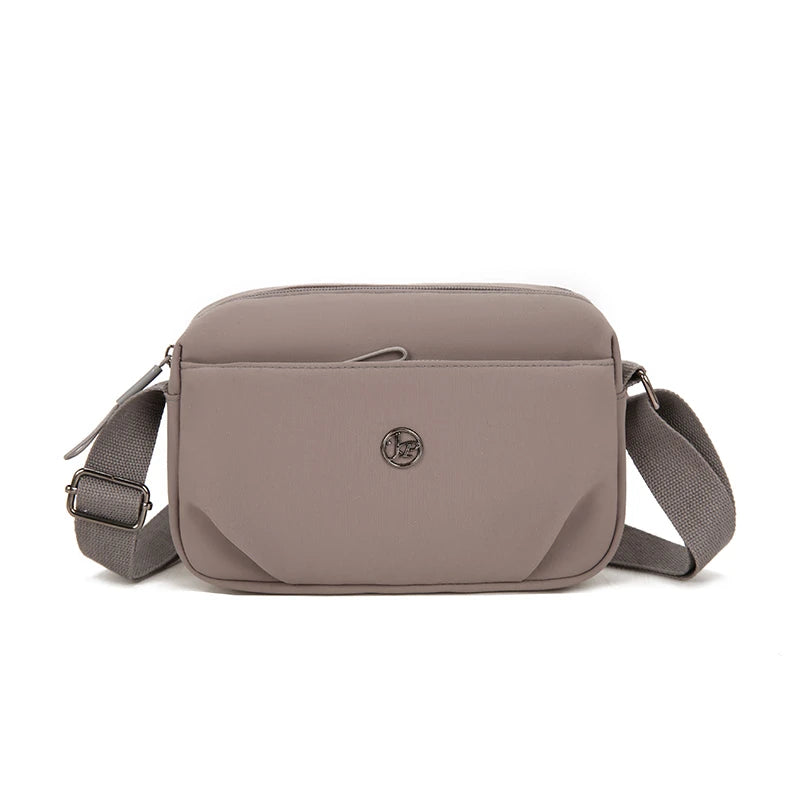 Bolso cruz impermeable de nylon topo con solapa y correa ajustable.