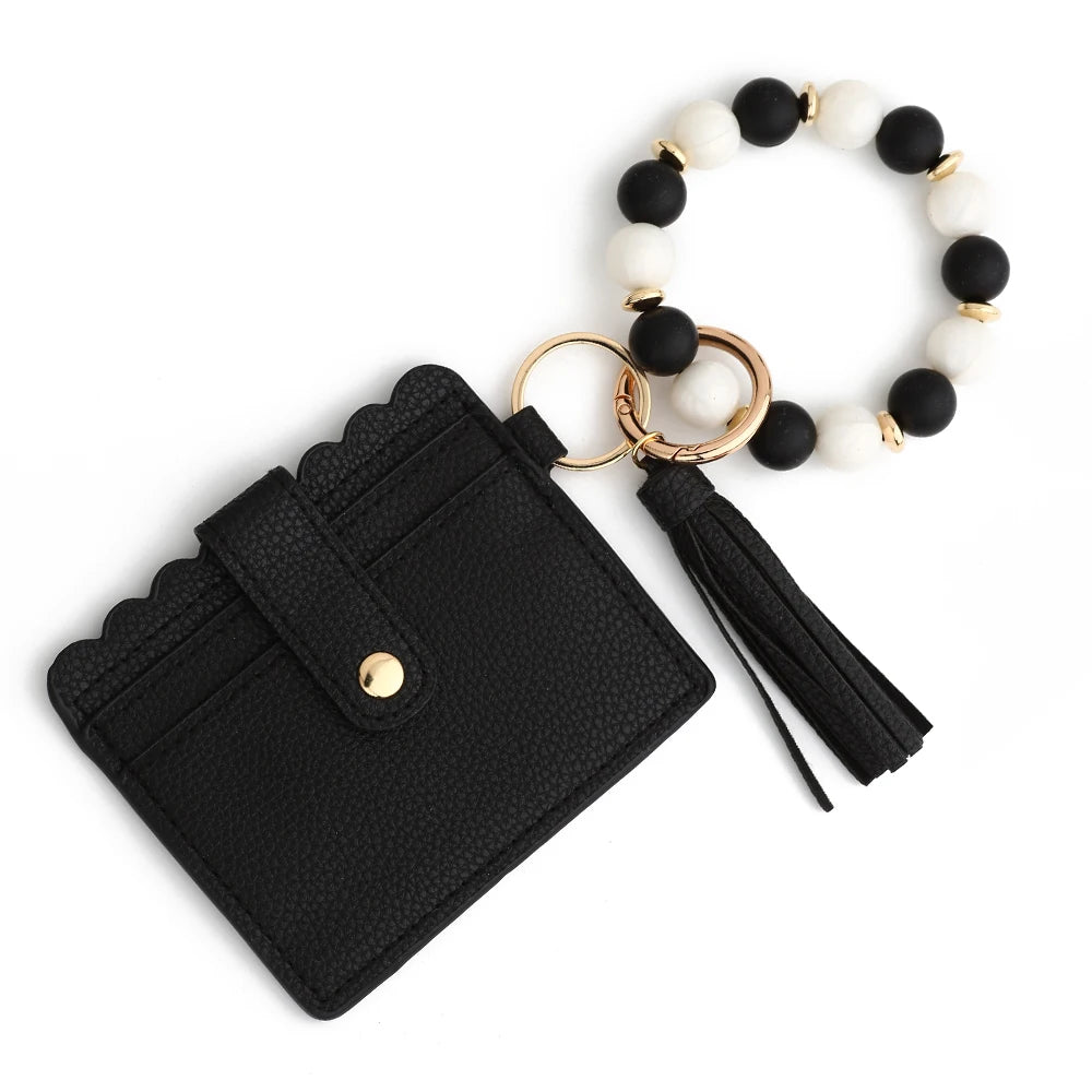 Black leather card wallet with a gold-toned chain and white and black silicone beads.