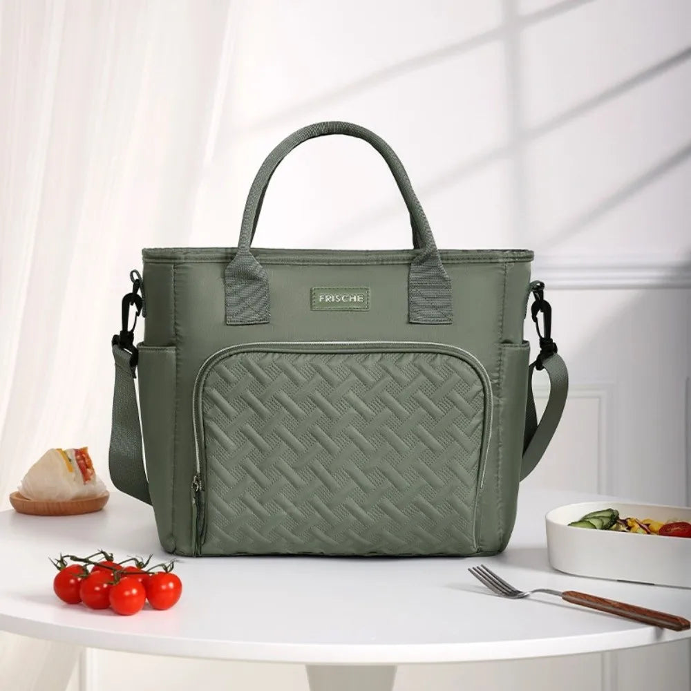 A green insulated lunch bag with a handle is displayed on a white table.
