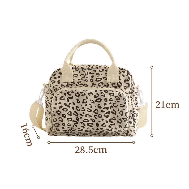 A beige floral corduroy insulated lunch bag with a leopard print pattern.