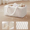 A white Flannel Diaper Caddy organizer with removable dividers and fluffy flannel fleece shown on a light carpet.