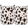 Un ensemble de paniers à linge en tissu blanc avec un motif vache noire.