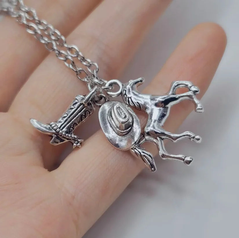 Silver keychain set featuring a cowboy boot, hat, and horseshoe charms on a silver chain