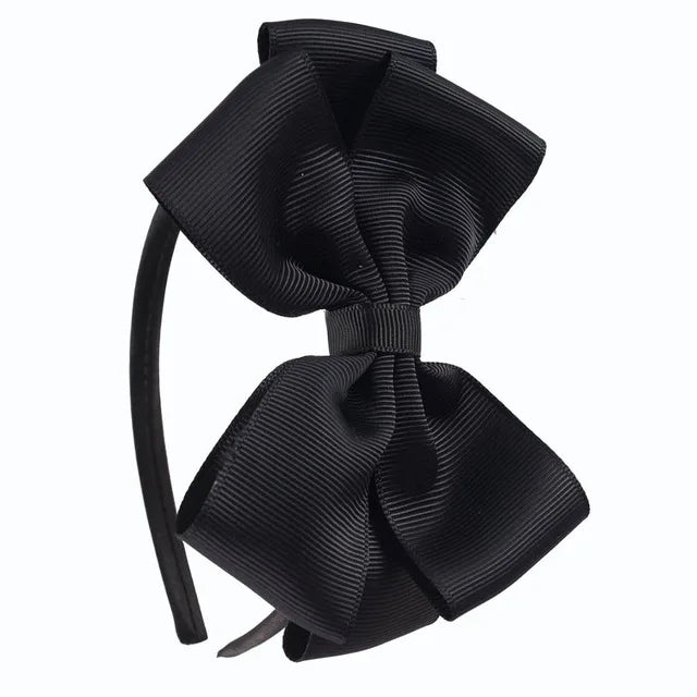 A black satin bow headband is shown against a white background.