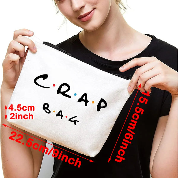 A white toiletry bag with black text reading CRAP BAG shown being held by a person.
