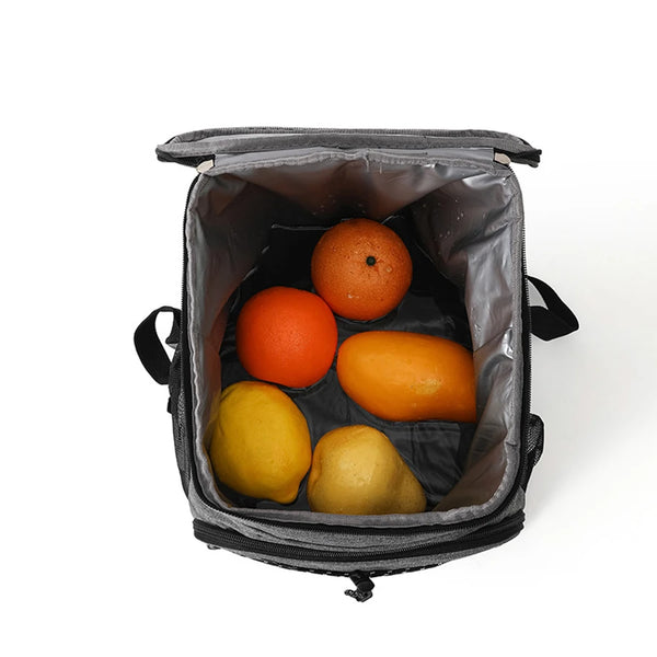 A black insulated lunch backpack with a waterproof shell containing several fresh oranges and a lemon.