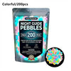 A package of multicolor glow-in-the-dark pebbles for outdoor decoration, labeled as Night Guide Pebbles.