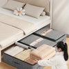A woman is folding an extra-large foldable underbed storage bag with reinforced handles onto a bed in a bright room.