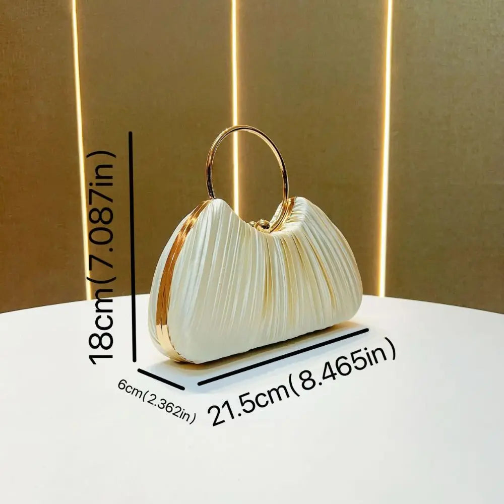 A white satin pleated evening clutch bag with a gold-toned handle displayed on a white surface.