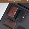 A display of brown and black leather card holders and a pen on a dark surface.
