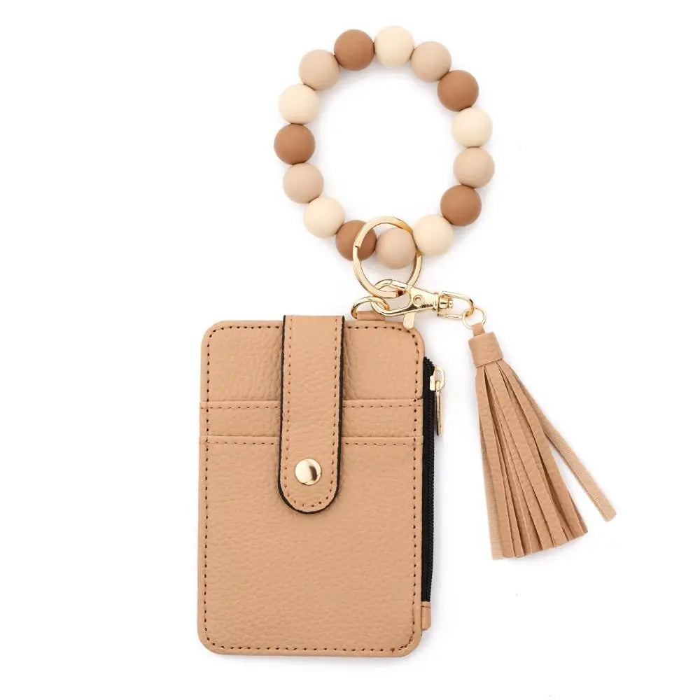 A beige beaded tassel keychain wristlet with a card holder attached to a round bead string.