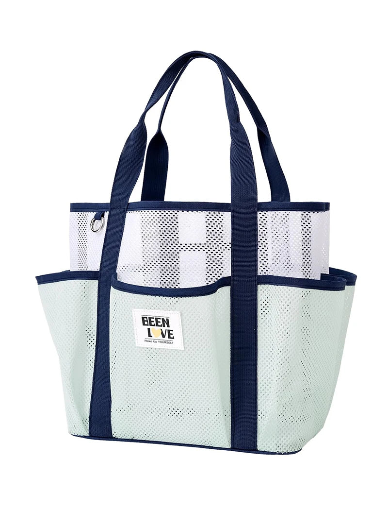 A light mint green mesh tote bag with navy blue handles and trim, featuring multiple pockets.