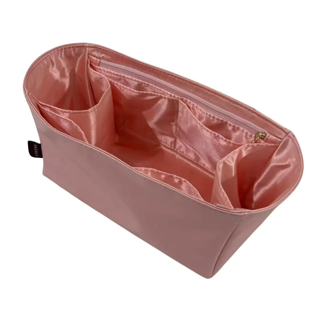 A pink luxury bag organizer insert featuring a silk lining and internal compartments.