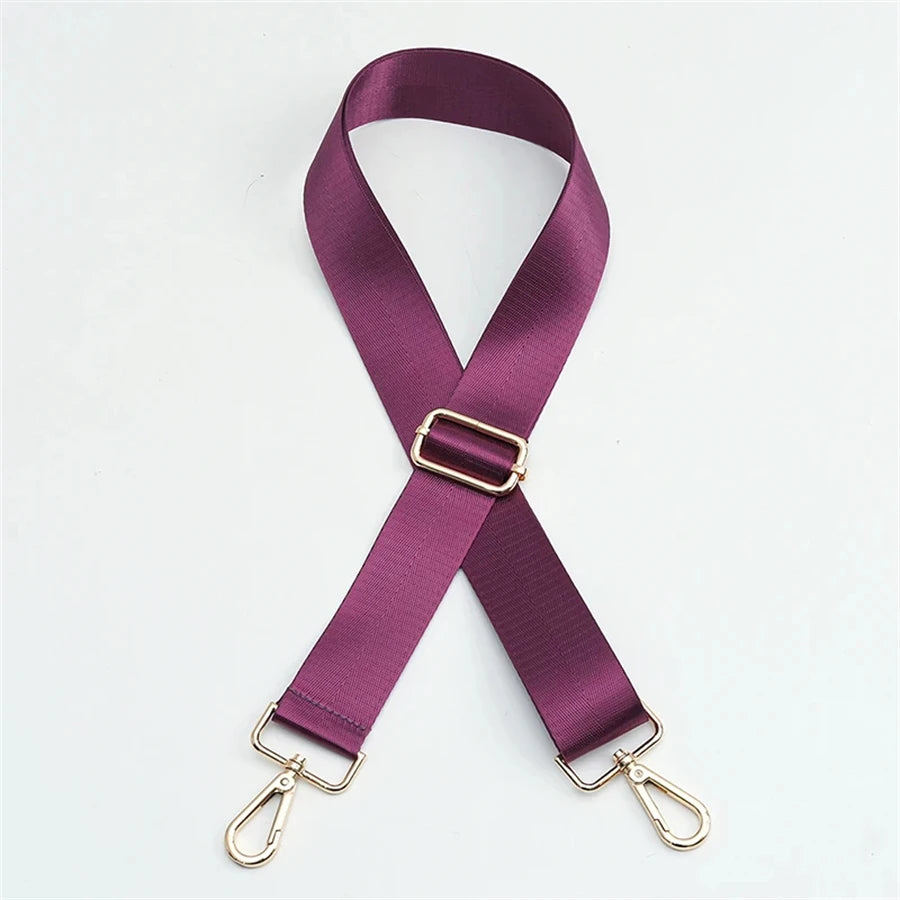 A purple nylon adjustable shoulder strap with gold-toned hardware.
