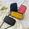A black multi-functional passport organizer with several colored document pouches is displayed on a white sheet.
