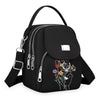 Sac bandoulière floral noir et durable avec fermeture éclair et sangle réglable.