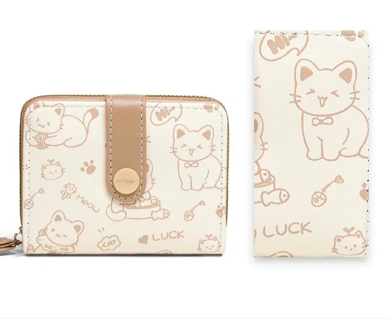 A beige cat cartoon coin purse and card holder wallet with a light brown leather strap.