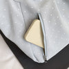 A light gray shoulder tote bag with white polka dots and a cream-colored interior lining visible through the zipper.