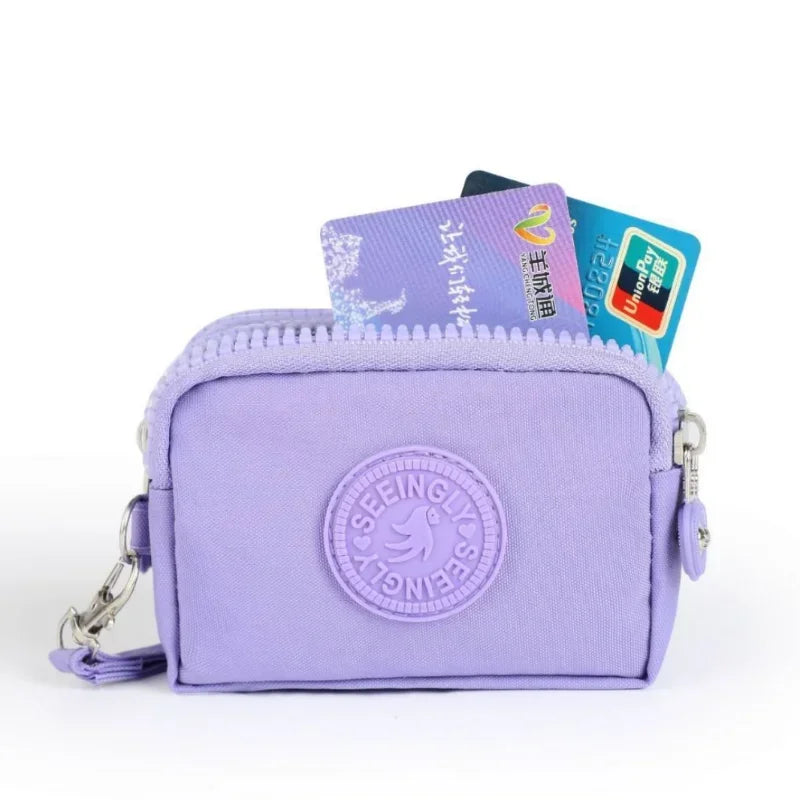 A purple compact three-layer nylon zipper pouch holding several credit cards.