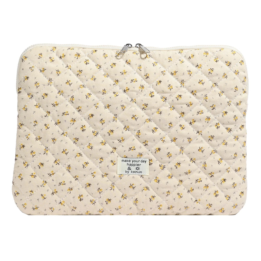 Funda acolchada para portátil de color crema con estampado floral amarillo.