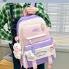 A purple and pink nylon backpack set with cartoon designs is carried by a person wearing a green plaid shirt.