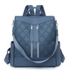 A navy blue leather anti-theft women's backpack with zippered pockets and a floral pattern.
