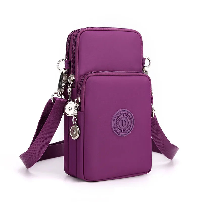A purple compact nylon crossbody phone bag with a silver chain and adjustable strap.