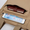 A tan canvas tote bag shows a brown leather wallet and a smartphone inside the zippered compartment.