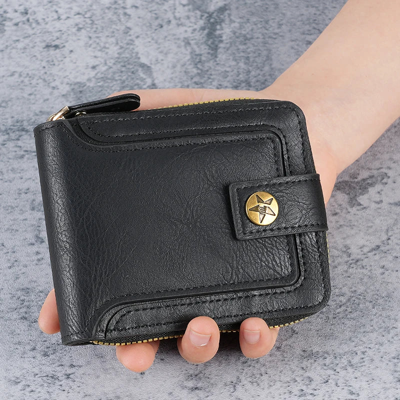 A black leather horizontal zipper card wallet is held in a person's hand against a gray background.