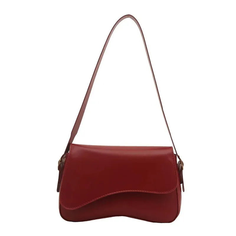 A maroon vintage curved flap shoulder bag made of soft faux leather.