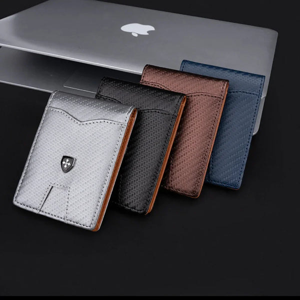 A set of five slim wallets in various colors including silver, gray, brown, and blue displayed next to an Apple laptop.