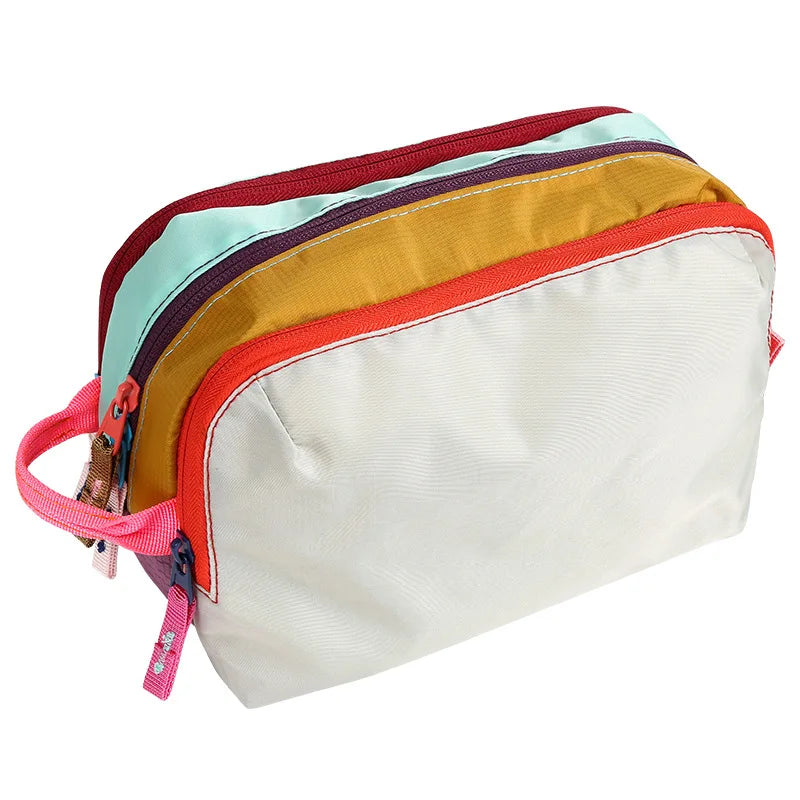 A multi-compartment travel toiletry organizer bag with colored accents and a light beige main body.