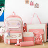 A pink and white 5-piece nylon backpack set with cartoon designs displayed on a wooden surface.