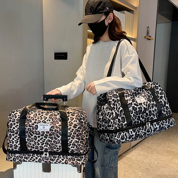 A woman holds a leopard print travel duffel bag with a shoe compartment in a modern indoor setting.