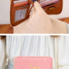 A pink passport wallet with a leather wrist strap is shown open and closed in various angles.