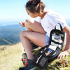 A woman sits on a grassy hill, holding an open black tactical EDC first aid kit.