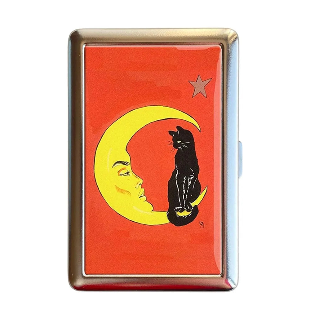 A vintage metal card holder featuring a design of a crescent moon and a black cat on an orange background.