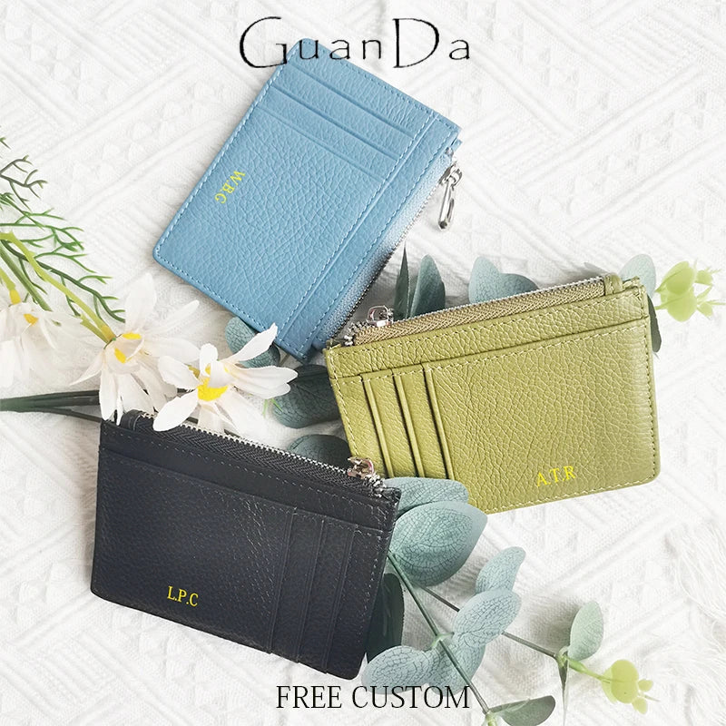 A collection of genuine leather card holders and coin purses in blue, olive green, and black tones.