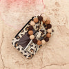 A leopard print pouch with a clear window and a beaded tassel keychain featuring brown and beige beads.