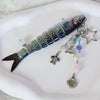 A realistic simulation fish keychain featuring iridescent blue and green scales, attached to a silver charm.